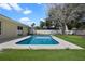 Backyard featuring a pool, a white fence, green grass and landscaping, and a mature shade tree at 854 Mendoza Dr, Kissimmee, FL 34758