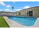 Backyard featuring a pool, a white fence, green grass and landscaping, and a palm tree in the distance at 854 Mendoza Dr, Kissimmee, FL 34758