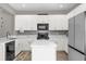 Well-lit kitchen featuring white cabinets, stainless steel appliances, and a kitchen island with white marble countertops at 9112 Grey Moss Dr, Orlando, FL 32832