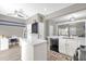 Bright, open-concept living area with a kitchen island, a desk, and an open doorway leading to another living area at 9112 Grey Moss Dr, Orlando, FL 32832
