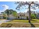Charming single-story home featuring a well-manicured lawn and mature tree, offering great curb appeal at 9681 Lake Douglas Pl, Orlando, FL 32817