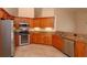 Bright kitchen features stainless steel appliances, wood cabinets, and granite counters at 9681 Lake Douglas Pl, Orlando, FL 32817
