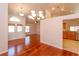 Expansive living area with hardwood floors, a chandelier, and seamless flow into the kitchen at 9681 Lake Douglas Pl, Orlando, FL 32817