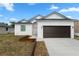 Charming single-story home featuring a white exterior, a two-car garage, and a well-manicured lawn at 9919 Cypress Park Dr, Orlando, FL 32824