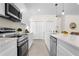 Modern kitchen features stainless steel appliances, quartz countertops, and ample white cabinetry at 9919 Cypress Park Dr, Orlando, FL 32824