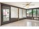 Enclosed sunroom has tiled floors, dark wood trim and natural light at 1030 Blue Horizon Dr, Deltona, FL 32725