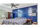 Stylish bedroom with a dark blue paneled accent wall, patterned bedspread, and ample natural light at 105 Elizabeth Ave, Altamonte Springs, FL 32701