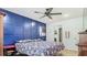 Primary bedroom features a striking blue accent wall, ceiling fan, and neutral tile floors at 105 Elizabeth Ave, Altamonte Springs, FL 32701