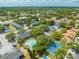 Aerial view of community with pool, tennis court, and lush landscaping in a desirable neighborhood at 130 Lewfield Cir # 130, Winter Park, FL 32792