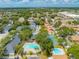 Aerial view highlighting community amenities, including pools and tennis courts, with mature trees at 130 Lewfield Cir # 130, Winter Park, FL 32792