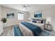 Well-lit bedroom with light wood floor, ceiling fan, and large bed with decorative pillows and blanket at 130 Lewfield Cir # 130, Winter Park, FL 32792