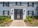Inviting front entrance featuring a black door, brick walkway, and well-maintained landscaping at 130 Lewfield Cir # 130, Winter Park, FL 32792