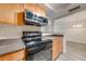 Bright kitchen featuring stainless steel appliances, gray countertops and wood cabinets at 130 Lewfield Cir # 130, Winter Park, FL 32792