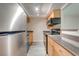 Bright kitchen featuring stainless steel appliances, wood cabinets, gray countertops, and vinyl flooring at 130 Lewfield Cir # 130, Winter Park, FL 32792