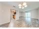 Open concept living room adjacent to kitchen with sliding glass door, and modern light fixture at 130 Lewfield Cir # 130, Winter Park, FL 32792