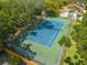 Aerial view of a well-maintained community tennis court surrounded by lush landscaping and fencing at 130 Lewfield Cir # 130, Winter Park, FL 32792