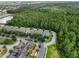Overhead view showcasing a residential neighborhood surrounded by lush forest and a tranquil pond at 14743 Driftwater Dr, Winter Garden, FL 34787