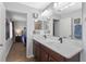 Bathroom with a double sink vanity, large mirror, and doorway to a bedroom at 14743 Driftwater Dr, Winter Garden, FL 34787