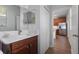 Bathroom showcasing vanity, mirror, and doorway view into the bright kitchen at 14743 Driftwater Dr, Winter Garden, FL 34787