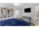 Comfortable bedroom featuring stylish decor, mounted TV, and wood-look flooring at 14743 Driftwater Dr, Winter Garden, FL 34787