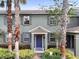 Inviting two-story home boasts a blue door, lush landscaping, and curb appeal at 14743 Driftwater Dr, Winter Garden, FL 34787