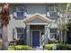 Charming home exterior features a blue front door, gray shutters, and neatly trimmed landscaping at 14743 Driftwater Dr, Winter Garden, FL 34787