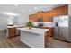 The kitchen features wood cabinets, stainless appliances, white countertops, and island seating at 14743 Driftwater Dr, Winter Garden, FL 34787