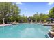 Large community pool with lounge chairs and sun umbrellas on a sunny day at 14743 Driftwater Dr, Winter Garden, FL 34787