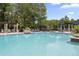 Community pool with many lounge chairs and sun umbrellas for relaxing at 14743 Driftwater Dr, Winter Garden, FL 34787