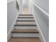 Clean staircase featuring wood treads, white risers, and a modern handrail at 14743 Driftwater Dr, Winter Garden, FL 34787