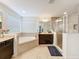 Bright bathroom featuring a soaking tub, glass shower, and double vanity sink at 1706 Leatherback Ln, St Cloud, FL 34771