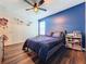 Bedroom featuring wood floors, ceiling fan, and decorated door at 1706 Leatherback Ln, St Cloud, FL 34771