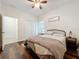 Well-lit bedroom with wood floors, a ceiling fan, and a view of the closet and attached bathroom at 1706 Leatherback Ln, St Cloud, FL 34771