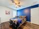 Bedroom featuring blue accent wall, wood floors, and a ceiling fan at 1706 Leatherback Ln, St Cloud, FL 34771