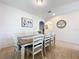 Dining area with a natural wood table, neutral walls, tiled floors, and a decorative painting on the wall at 1706 Leatherback Ln, St Cloud, FL 34771