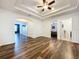 Open hallway featuring wood-look flooring and a tray ceiling with access to other rooms at 1706 Leatherback Ln, St Cloud, FL 34771