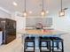 Kitchen island with granite countertops and seating, lit by pendant lights, set against a backdrop of gray cabinets at 1706 Leatherback Ln, St Cloud, FL 34771
