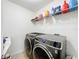 Modern laundry room featuring front-load washer and dryer, and shelving at 1706 Leatherback Ln, St Cloud, FL 34771
