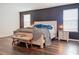 A stylishly furnished main bedroom with wood floors and modern decor, including a dark accent wall at 1706 Leatherback Ln, St Cloud, FL 34771