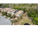 Aerial view of townhomes with tile roofs, solar panels, and landscaping near a pond at 1801 Nice Ct, Kissimmee, FL 34747