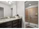 Bathroom with dual sink vanity, granite countertops and a tiled glass shower at 1801 Nice Ct, Kissimmee, FL 34747