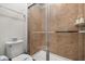 Neutral tiled bathroom with glass shower doors, commode, and bathroom accessories at 1801 Nice Ct, Kissimmee, FL 34747