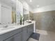 Bright bathroom featuring a double vanity with gray cabinetry and a tiled walk-in shower at 1929 Tropical Palms Cir, Kissimmee, FL 34747