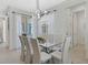 Contemporary dining room with glass table, seating for eight, modern light fixture and white walls at 1929 Tropical Palms Cir, Kissimmee, FL 34747