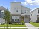 Contemporary two-story home featuring stone accents, a manicured lawn, and a one-car garage at 1929 Tropical Palms Cir, Kissimmee, FL 34747