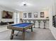 This game room offers a sleek billiards table, bar seating, and a large-screen television for entertainment at 1929 Tropical Palms Cir, Kissimmee, FL 34747