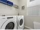 Bright laundry room with washer, dryer, shelving and window at 1929 Tropical Palms Cir, Kissimmee, FL 34747