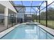 Sparkling in-ground pool surrounded by a screened enclosure and lush landscaping at 1929 Tropical Palms Cir, Kissimmee, FL 34747