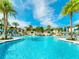 Large outdoor swimming pool with palm trees, lounge chairs, and clear blue water at 1929 Tropical Palms Cir, Kissimmee, FL 34747