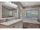 Bathroom with double sinks, soaking tub, and stone accent wall, exuding elegance and tranquility for a spa-like experience at 202 Sweetwater Club Blvd, Longwood, FL 32779